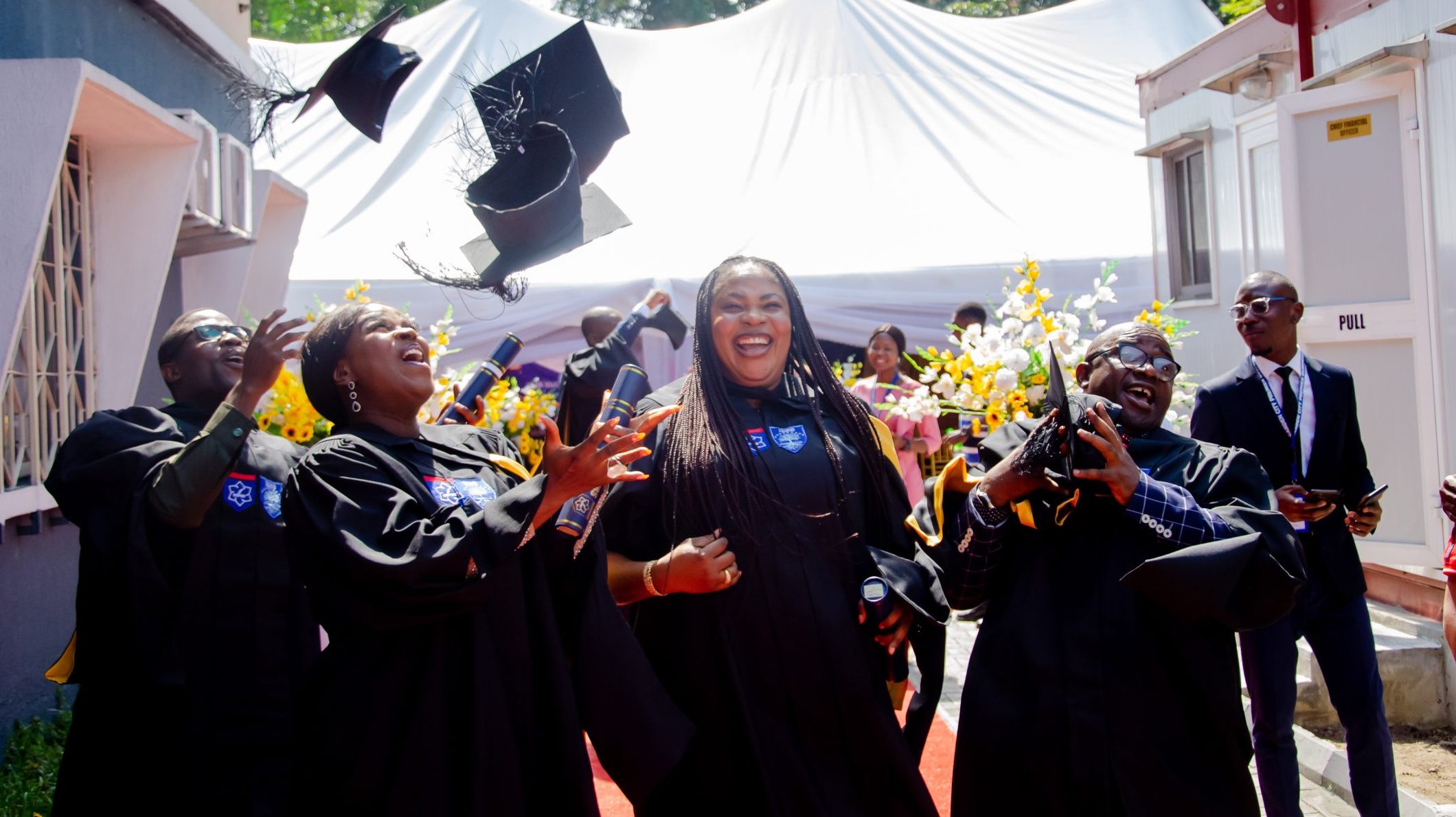 Garden City Premier Business School graduates celebrating and throwing their caps